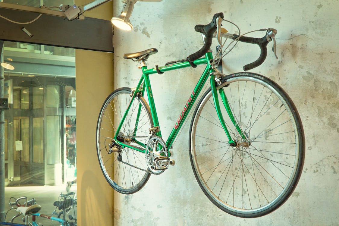 Free Green Road Bicycle Hanged on Wall Stock Photo