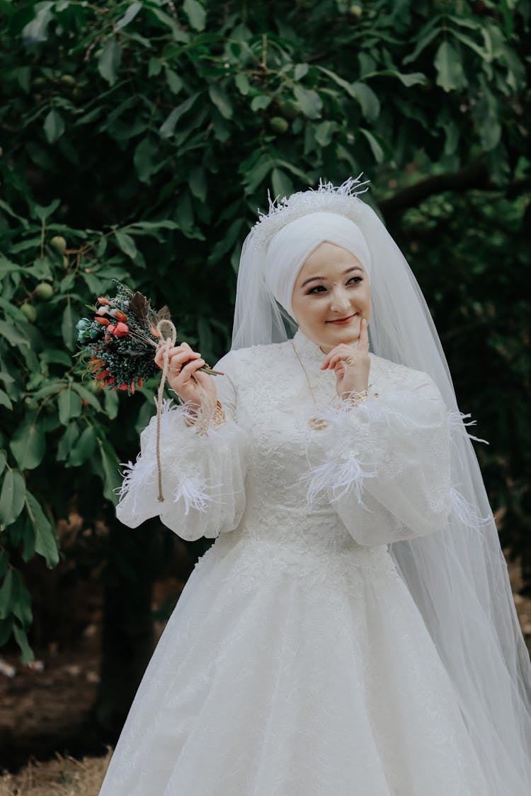 Woman In White Wedding Dress Holding Small Dry Bouquet 