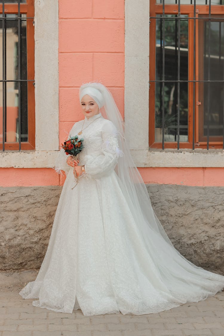 Wedding Photo Of Smiling Bride Standing By Classic Building Wall