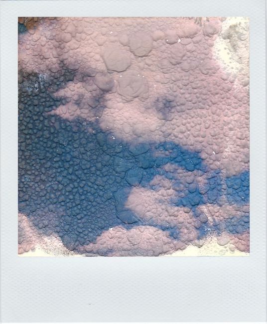 Artistic abstract cloudscape resembling a textured skyscape captured in a vintage Polaroid style.