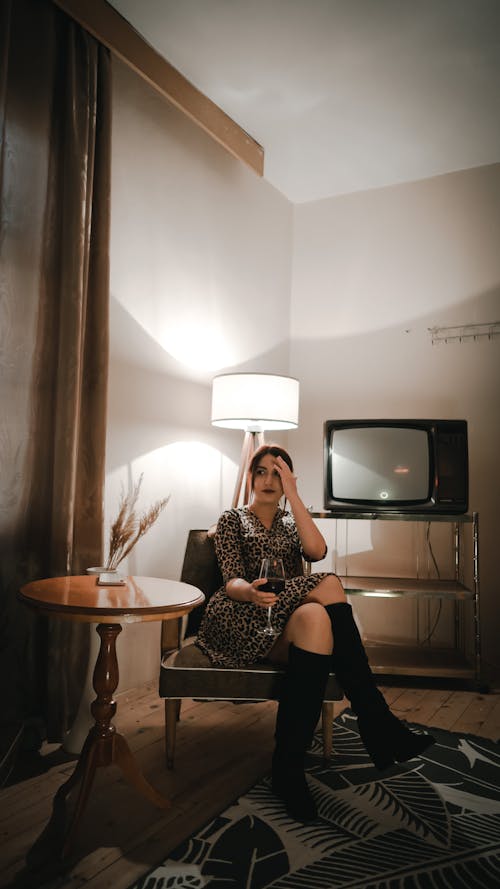 Woman Sitting in Room with Lamp and Television