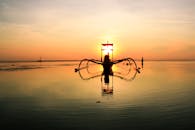 宁静的场景中，船的轮廓映衬在壮丽的海洋日出下，令人惊叹