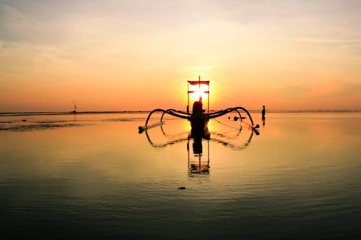 宁静的场景中，船的轮廓映衬在壮丽的海洋日出下，令人惊叹