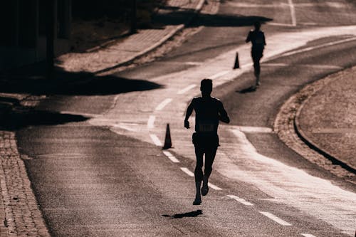 Free Silhouette of a Man Running on the Street Stock Photo