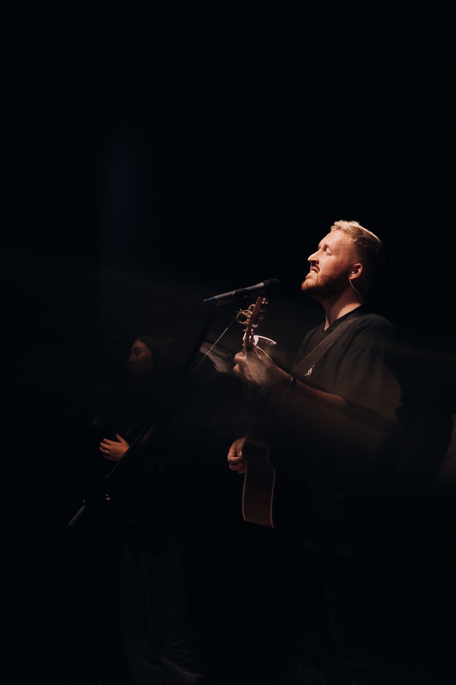 Two musicians performing with guitars on a small stage — photo by Ekaterina Shishkonakova on Pexels