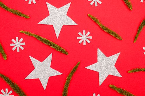 Free A vibrant Christmas-themed design with glitter stars and green pine branches. Stock Photo