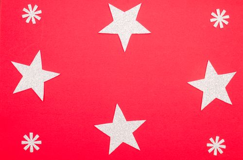 Free Bright red background adorned with sparkling silver stars, perfect for holiday decorations. Stock Photo