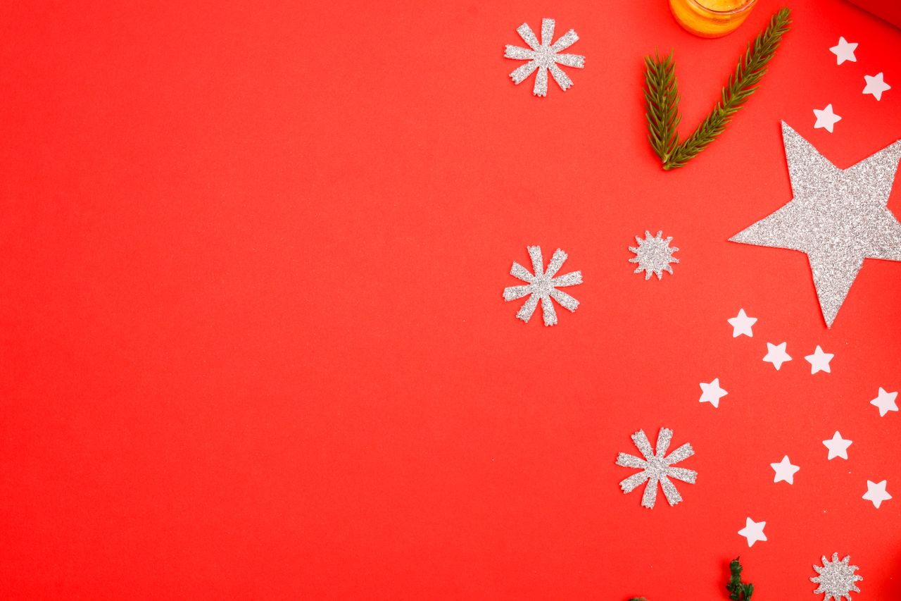 a vibrant red surface with festive christmas ornaments and decorations