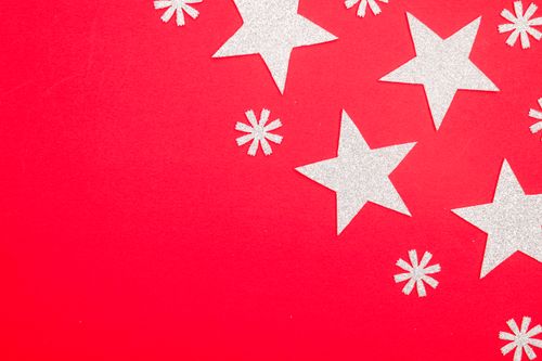 Free Silver glitter stars and snowflakes arranged on bright red surface, perfect for holiday themes. Stock Photo
