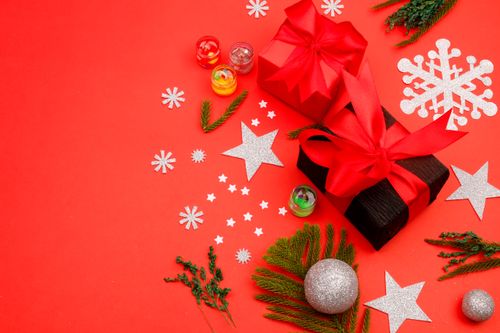 Free A vibrant Christmas gift scene with red and silver decorations on a bright red background. Stock Photo