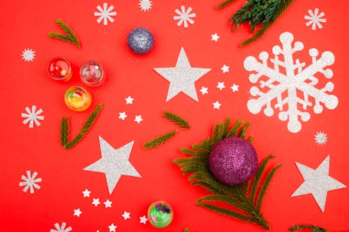 Flat Lay Photography of Christmas Ornaments on Red Surface