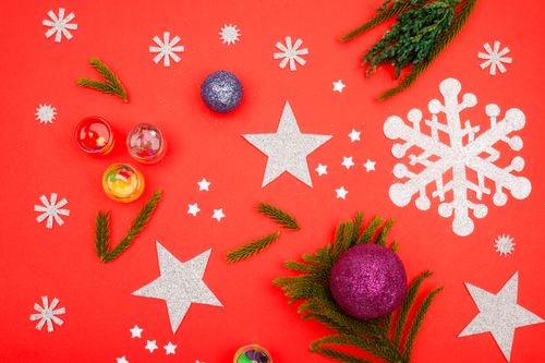Free A vibrant flat lay of Christmas ornaments and decorations on a bright red surface. Stock Photo