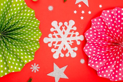 Free Colorful festive paper decorations for Christmas with a polka dot design on a vivid red background. Stock Photo