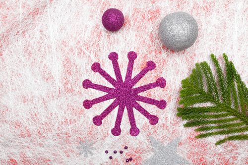 Free Colorful Christmas decorations on textured backdrop with greenery branch. Stock Photo