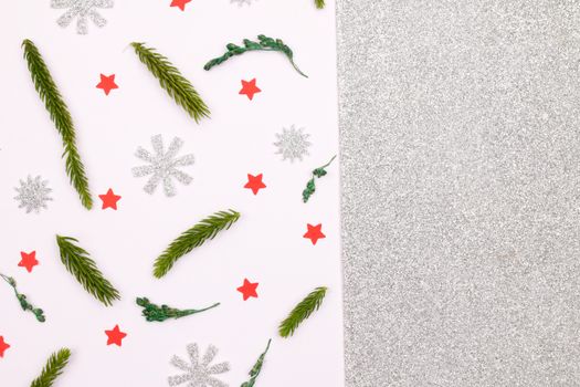 A festive Christmas background featuring pine leaves, snowflakes, and bright red stars on a glittery backdrop.
