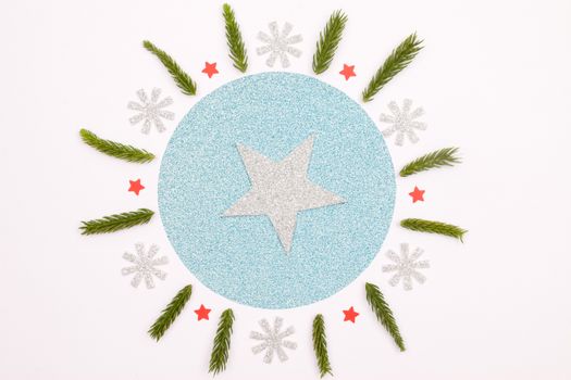 Glittery blue and silver circle with star, pine branches, perfect for holiday cards.