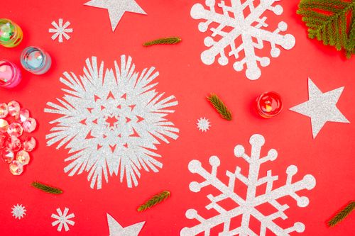 Free Bright and festive red and silver Christmas flat lay with snowflakes and stars. Stock Photo