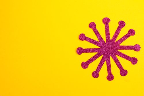 Free Pink glitter starburst on vibrant yellow background with ample copy space for creative design. Stock Photo