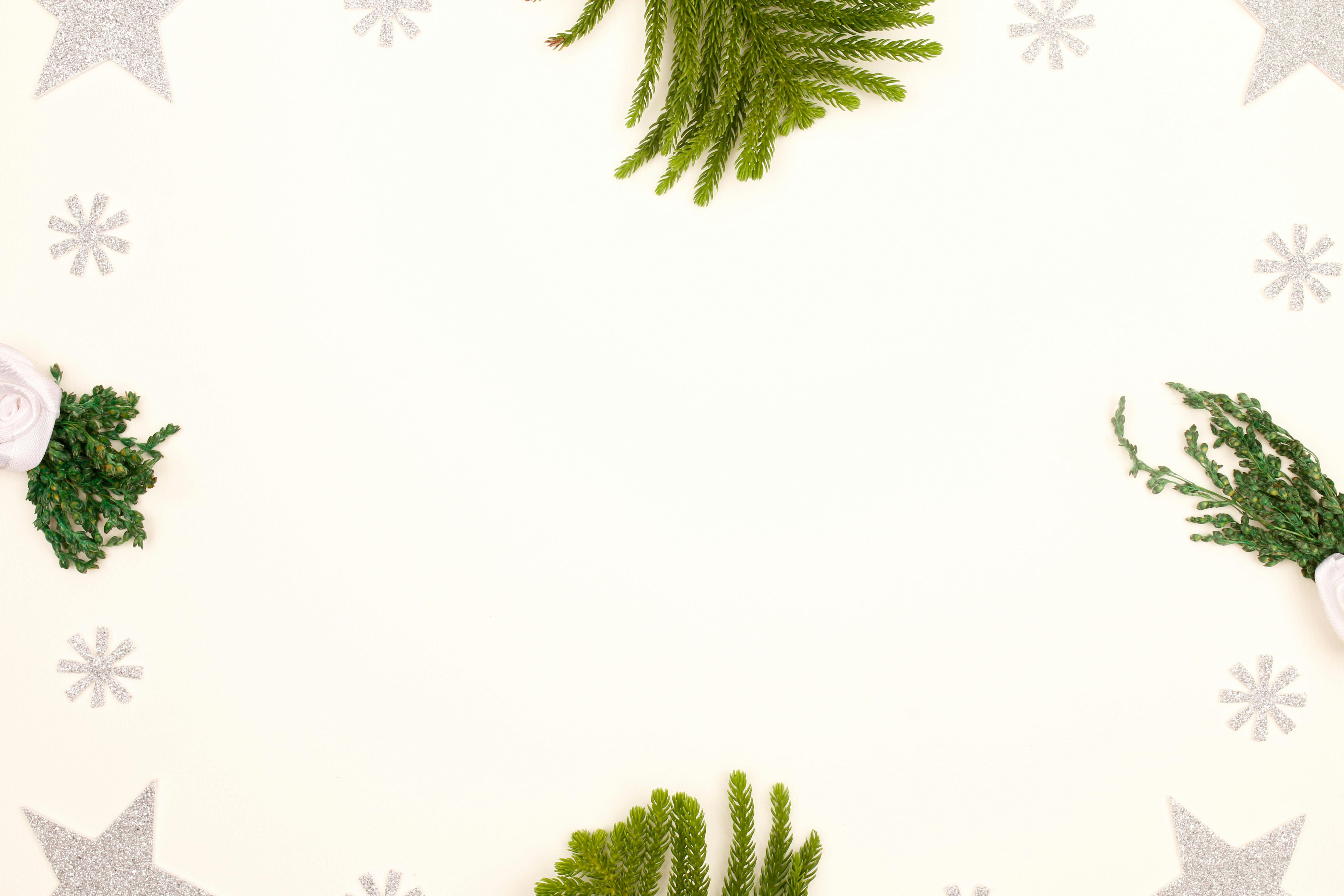 Top view of Christmas decorations with copy space and greenery on white background.