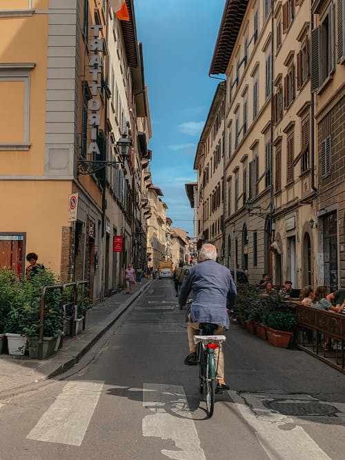 Back View of a Person Riding a Bicycle in the Street