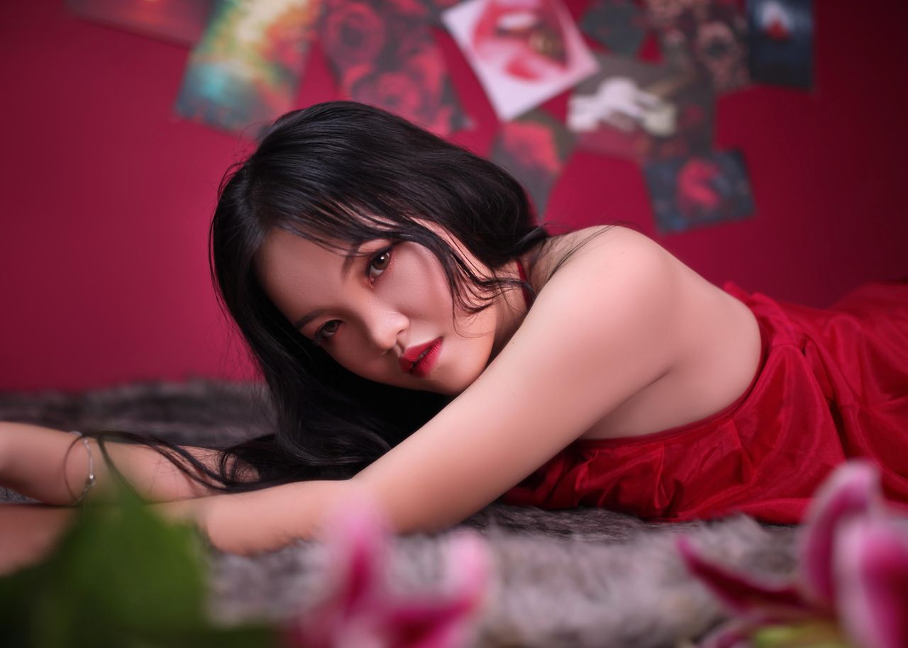 artistic indoor portrait of an adult woman lying on a fuzzy surface su