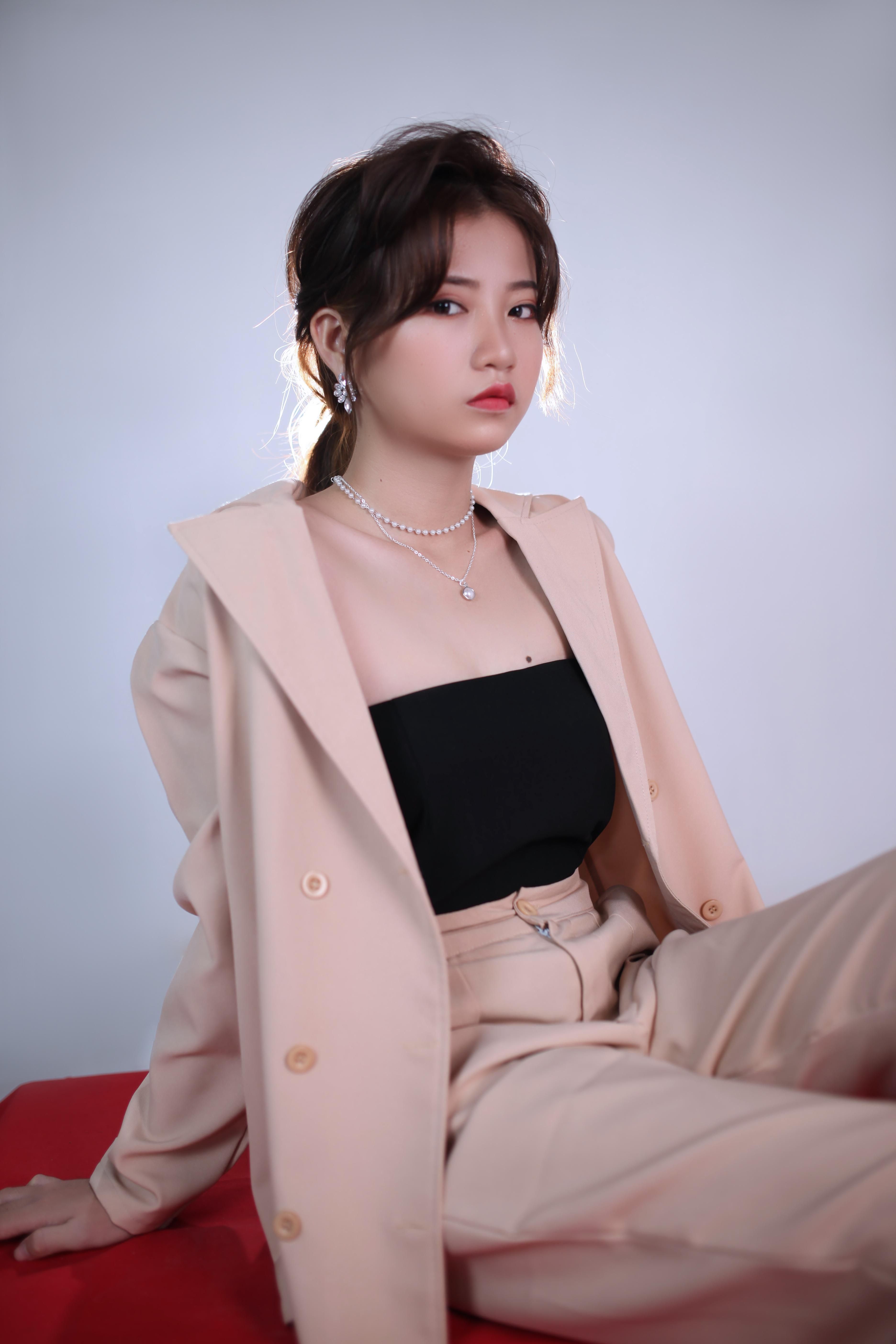 Chic studio portrait of a fashionable woman in a beige outfit posing confidently.