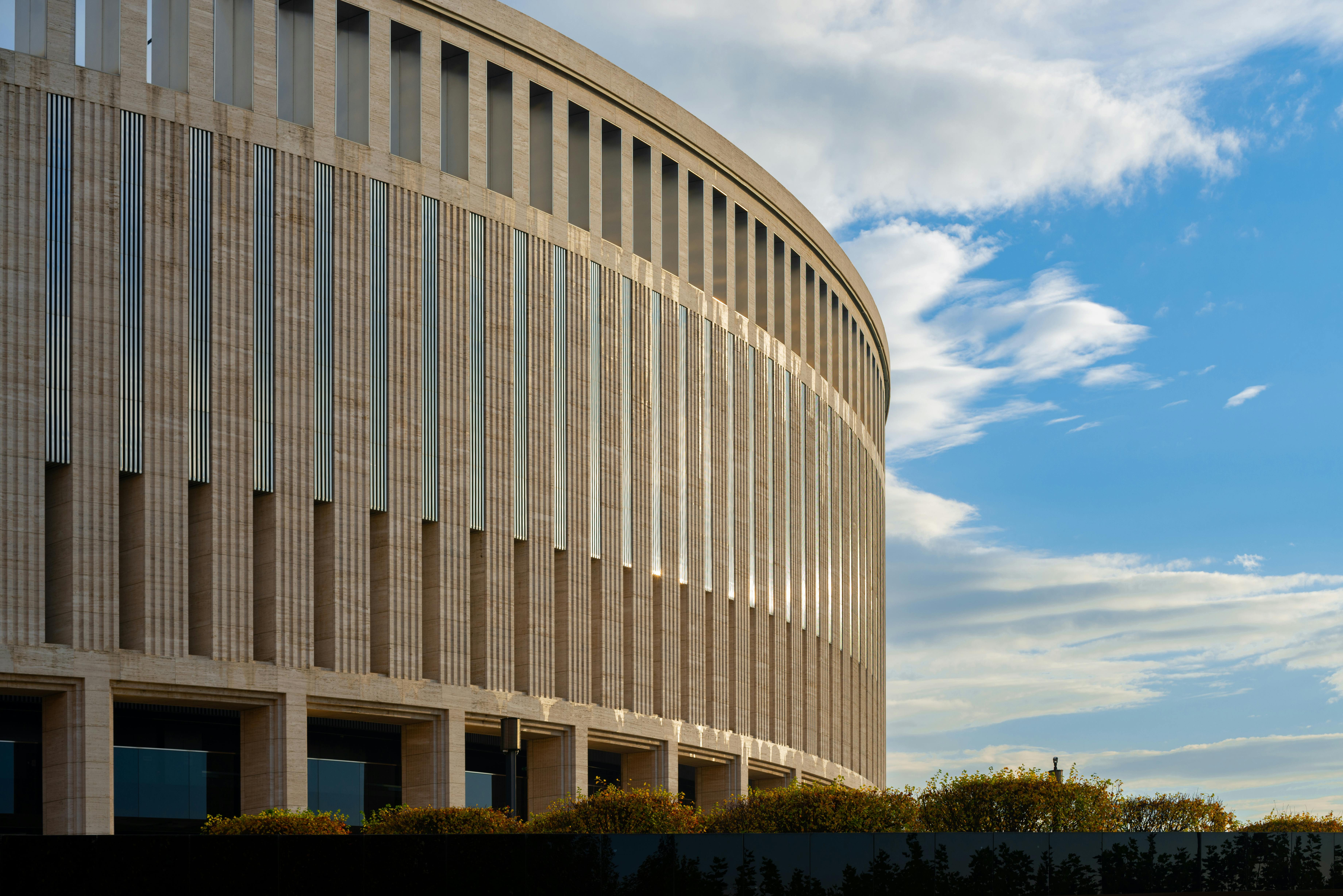 Stunning view of the Krasnodar Stadium exterior with a clear blue sky and clouds.