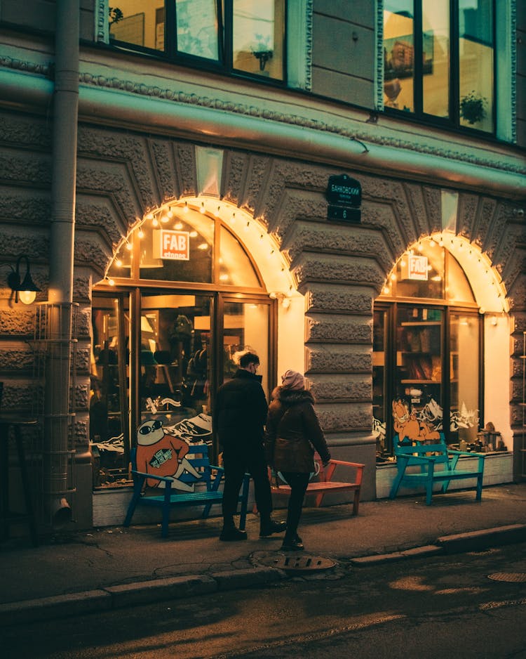 A Couple Walking On A Sidewalk