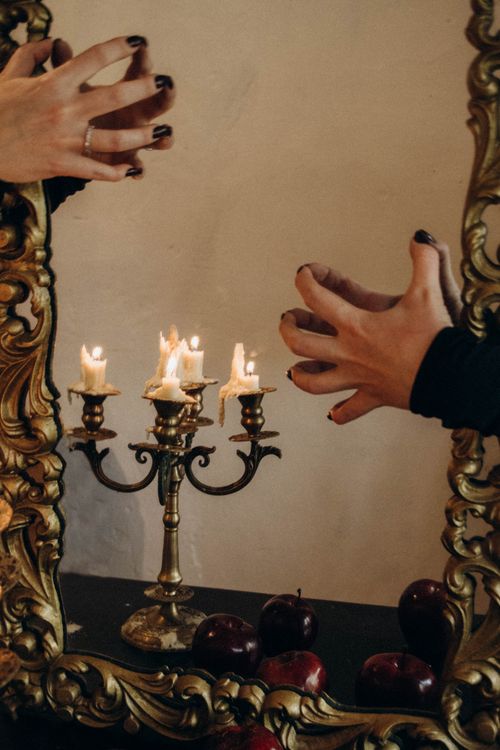 Free Mirror reflection featuring candlelit candelabra and hands adding a mysterious touch. Stock Photo