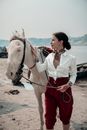 Woman in White Long Sleeve Shirt Riding White Horse