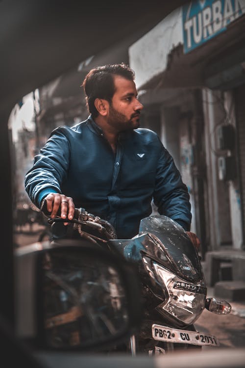 Man in Blue Long Sleeve Shirt Riding a Motorcycle