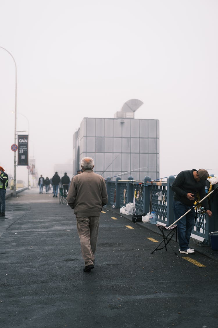 Back Of A Man Walking Down A Bridge