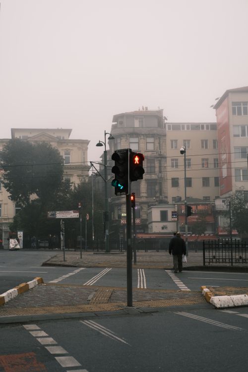 Free Misty city street with traffic lights and crosswalk, creating an urban atmosphere. Stock Photo