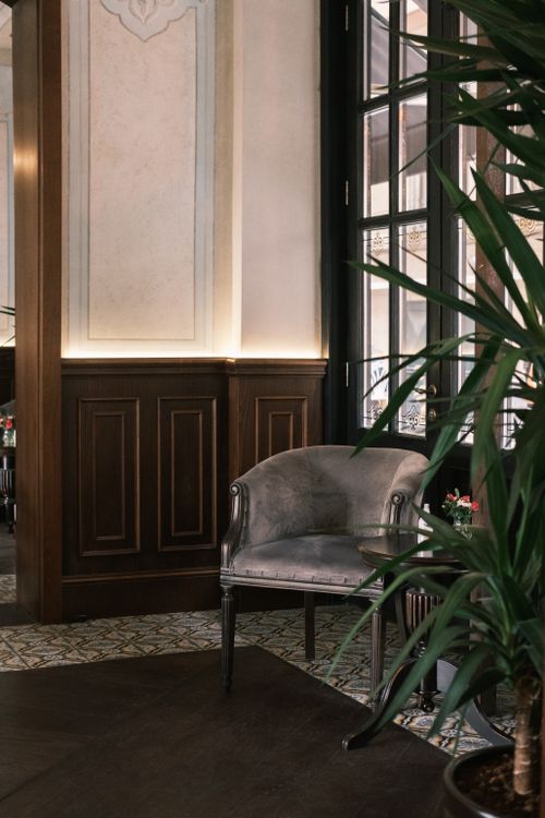 Free A sophisticated room featuring a plush armchair and stylish decor in a luxurious mansion setting. Stock Photo