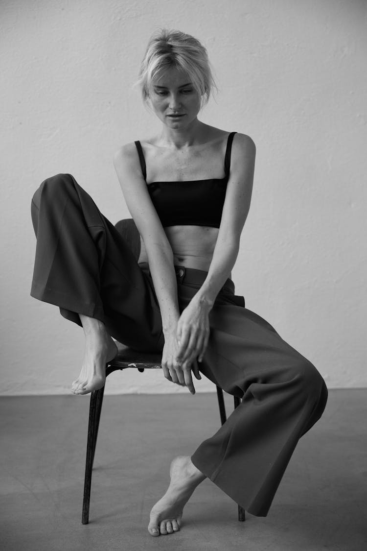 Woman Sitting On A Chair In An Empty Room