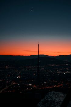 A stunning cityscape featuring a tower silhouette against a vibrant twilight sky.