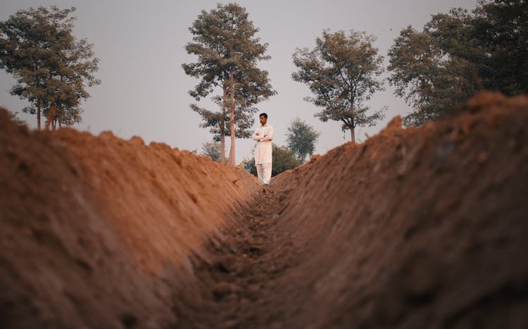 Person In White Shirt Standing On Brown Rock Formation