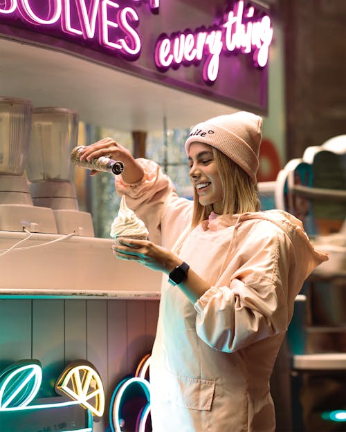 A Woman Pouring Syrup on an Ice Cream