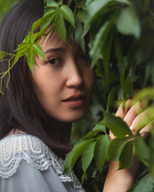 Young Brunette Woman Next to a Shrub 