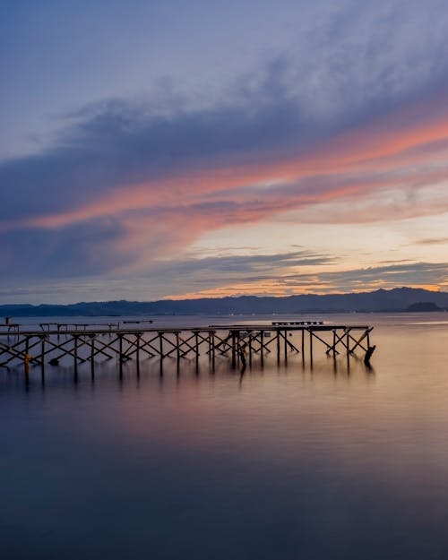 Brown Wooden Dock on Body of Water during Sunset