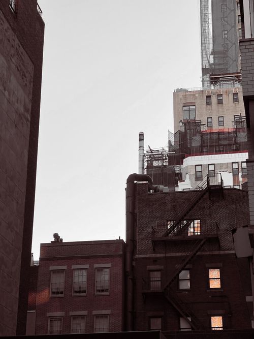 Free Cityscape featuring urban buildings and fire escapes at dusk. Stock Photo