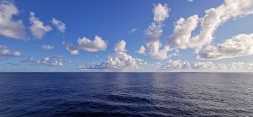 Free A serene ocean horizon with white fluffy clouds under a clear blue sky in Palma, Spain. Stock Photo