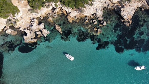 Aerial Photography of Two White Boats on the Ocean near Rocky Coastline