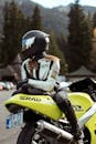 Person in Motorcycle Racing Suit and Helmet Sitting on a Suzuki GSX-R