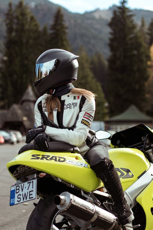Free Person in Motorcycle Racing Suit and Helmet Sitting on a Suzuki GSX-R Stock Photo
