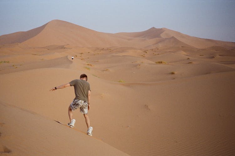 Man Riding Dune On Sandboard