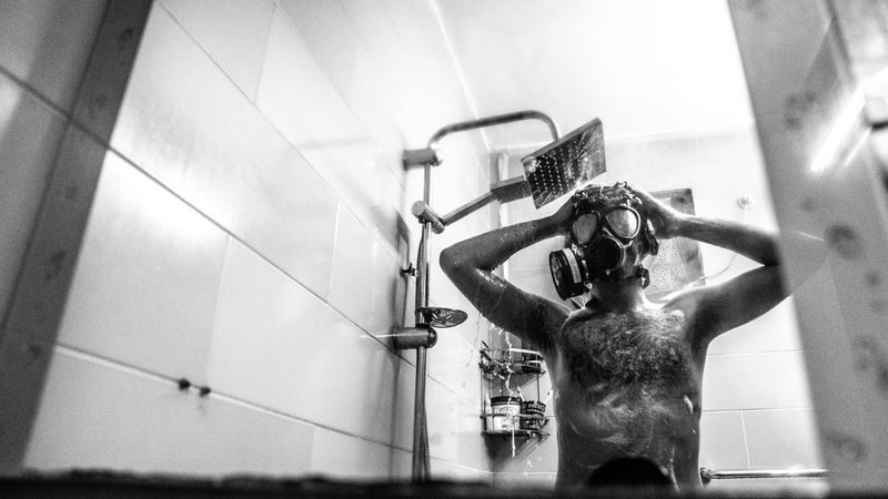 Person taking a shower with high water pressure in a modern bathroom