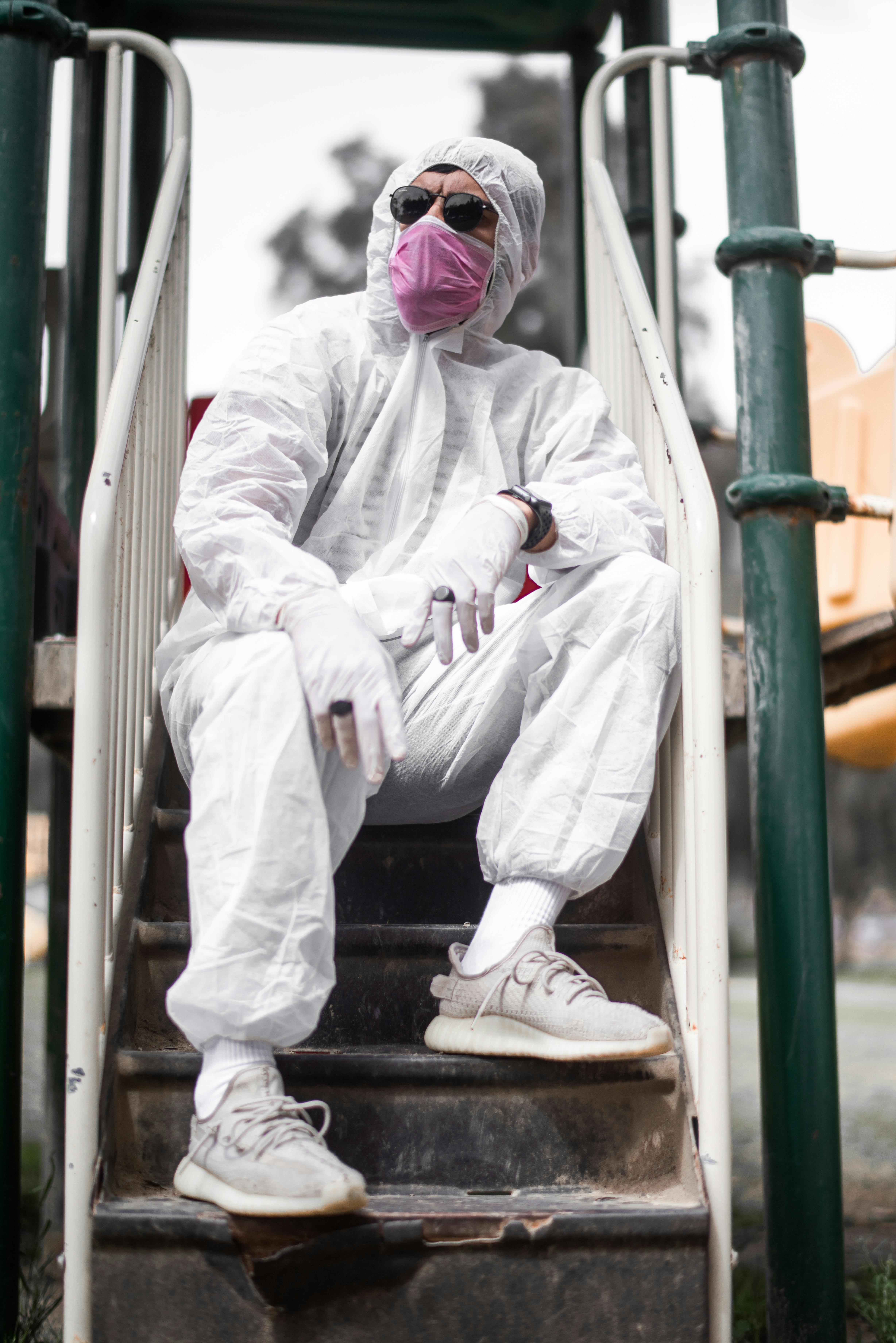 A Person Wearing a White Personal Protective Equipment while Sitting on ...