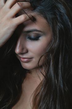 Close-up portrait of a woman with flowing hair and closed eyes, exuding beauty and serenity.
