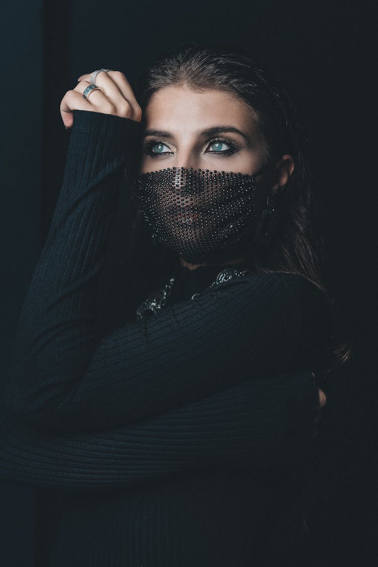 Close-Up Shot Of A Woman In Black Sweater Wearing Her Black Facemask